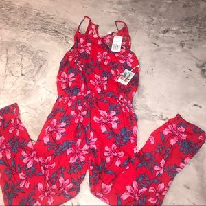 A red/pink/blue jumpsuit with floral detail.